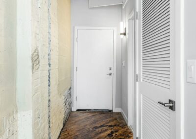 Hallway with mounted lighting and rustic wall.