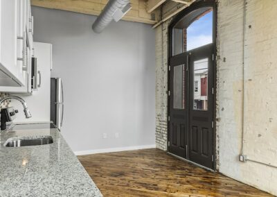 View from granite countertop of open concept kitchen with large renovated doors.